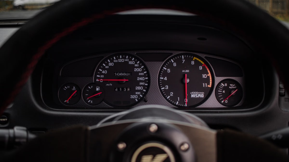 A close-up view of a car dashboard featuring speedometer, tachometer, and fuel gauge.